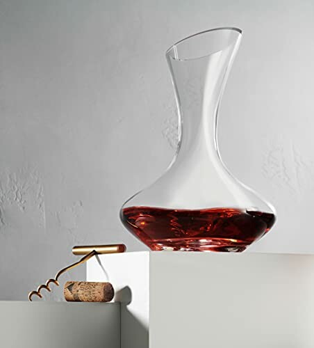 Glass wine decanter with corkscrew on ledge