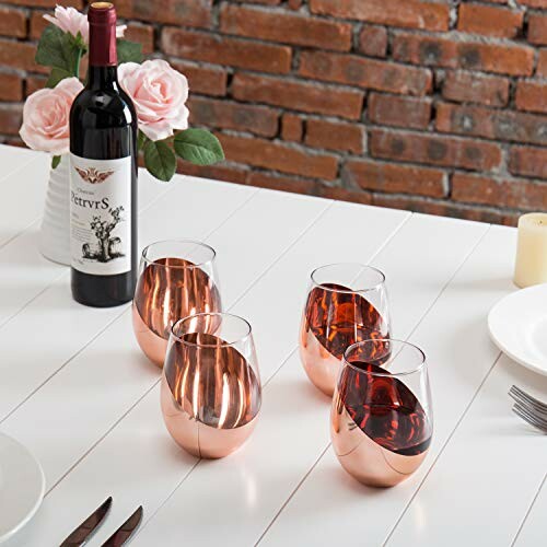 Wine bottle with four glasses on a table with roses