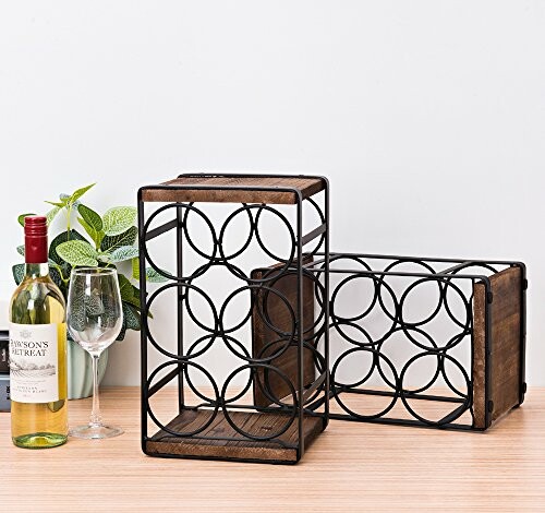 Two metal and wood wine racks with a wine bottle and glass on a table.