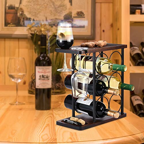 Wine rack with bottles and glass on wooden table